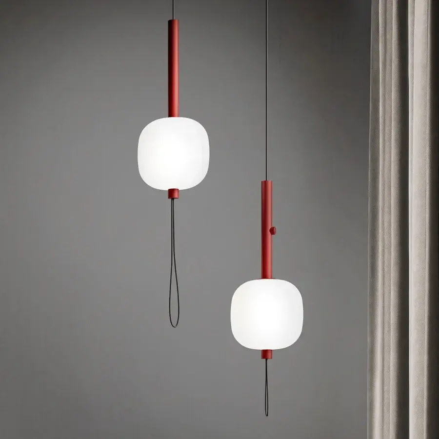 Elegant Kundalini Motus suspension lamp with rounded opal glass diffuser and striking red cylindrical metal support