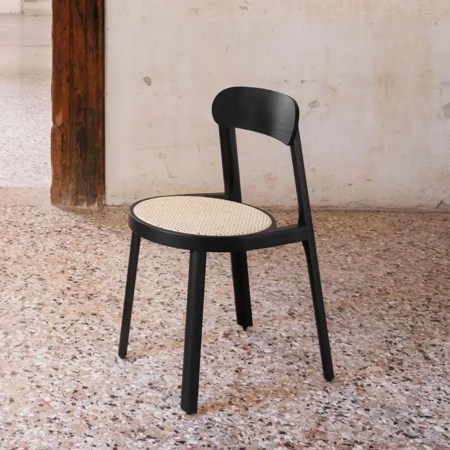 Distinguished Miniforms Brulla chair with black finished wood and tilted cane-webbed seat showcasing curves and straight lines