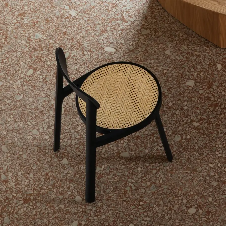 Superior Miniforms Brulla chair with a woven light tan cane seat and sleek black frame exhibiting balanced curves and lines