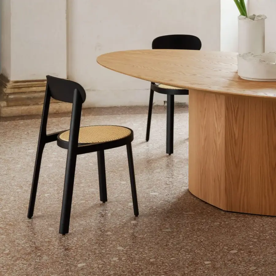 Distinguished Miniforms Brulla chair crafted in Italy with a tilted light tan cane seat and matte black wooden frame