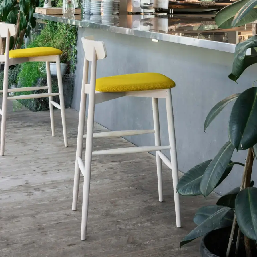 Distinguished Miniforms Claretta stool crafted in Italy with bright yellow textile and light-colored matte wood finish