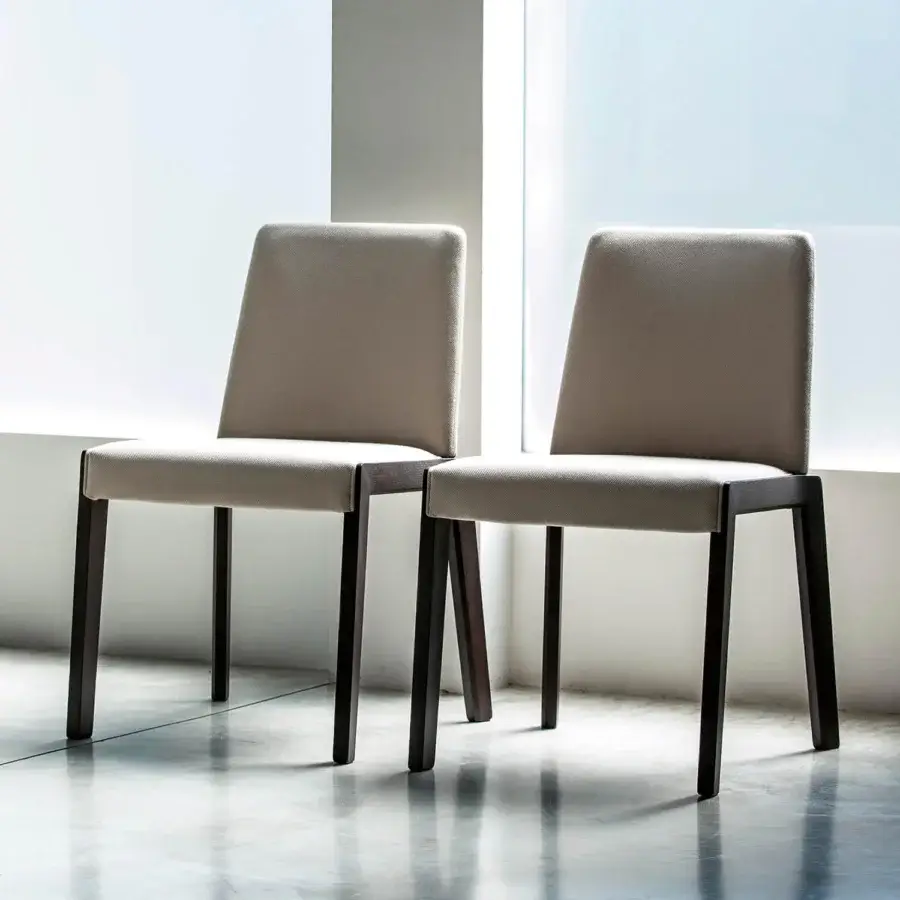 Exclusive Bross Bridget chair with neutral tan fabric and dark toned wood legs exhibiting a matte finish
