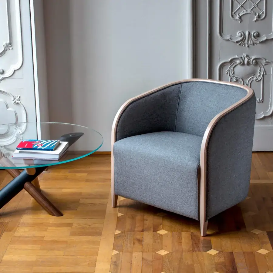 Elegant Bross Brig lounge chair with a gray textile and gracefully curved light wood frame crafted with a matte finish
