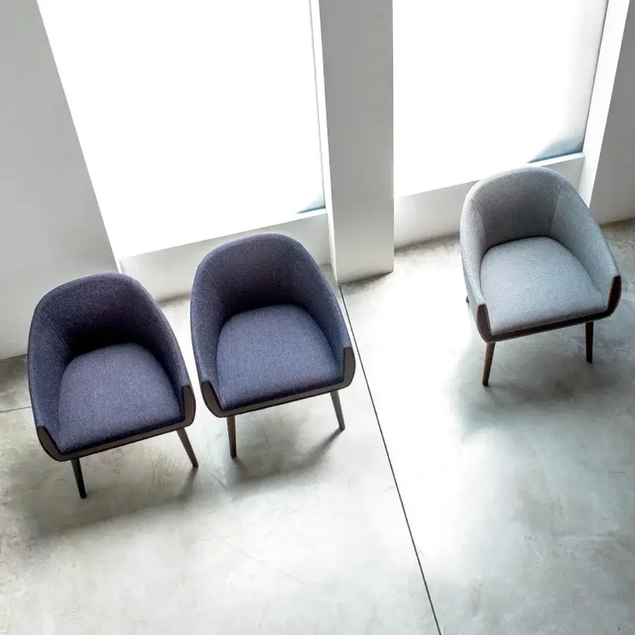 Handcrafted Bross Ginevra armchair in light gray textile with slender tapered wooden legs and polyurethane foam shell