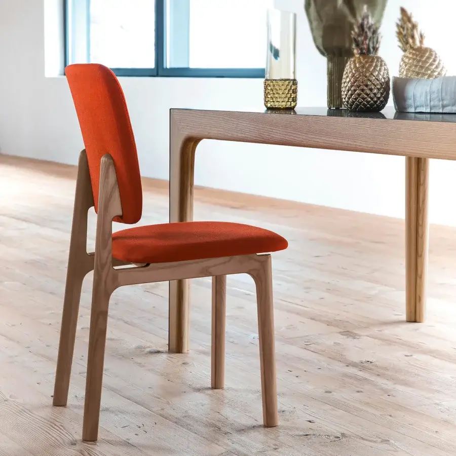 Distinguished Bross Gisa chair with vibrant orange premium fabric and light-toned wood, crafted with a matte finish