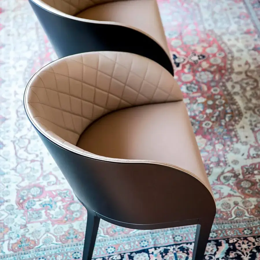Exclusive Bross Hug armchair with tan quilted textile and matte wood, built with slender dark legs