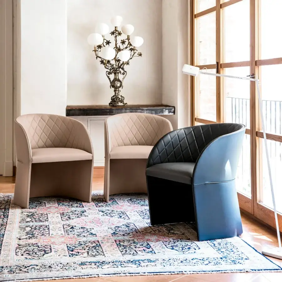 Elegant Bross Hug armchair with quilted light beige fabric upholstery and curved fully upholstered form