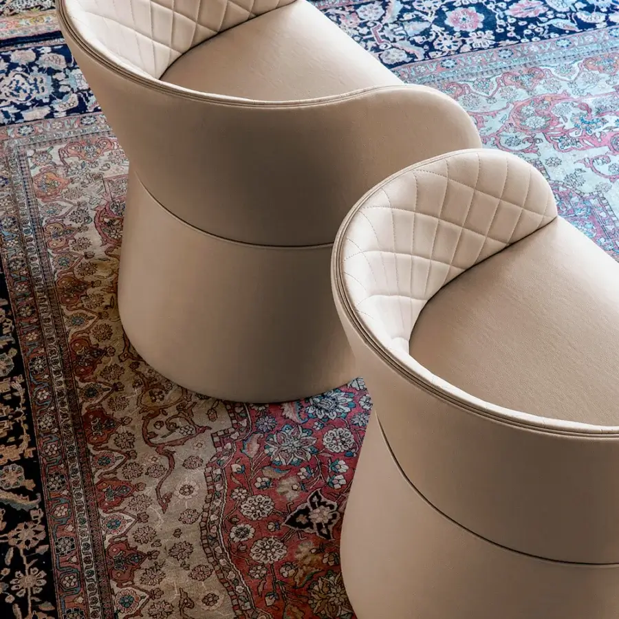 Distinguished Bross Hug armchair with quilted beige fabric upholstery and cylindrical base crafted in Italy