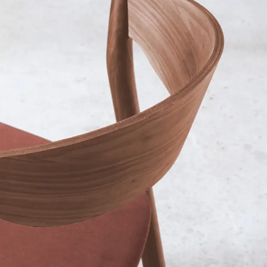 Superior Miniforms Tube chair with a curved form in reddish-brown textile and medium-toned brown wood frame