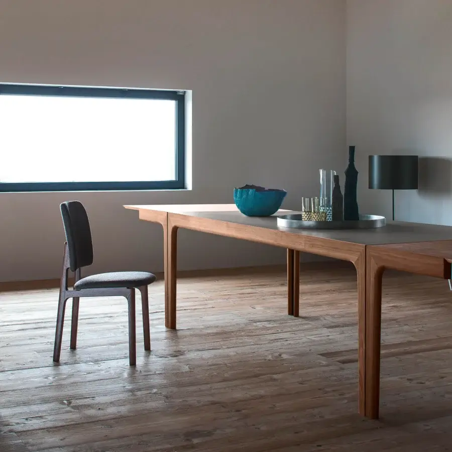 Distinguished Bross Amalong table crafted with solid ash showcasing a smooth medium-tone brown tabletop and uniquely curved leg supports