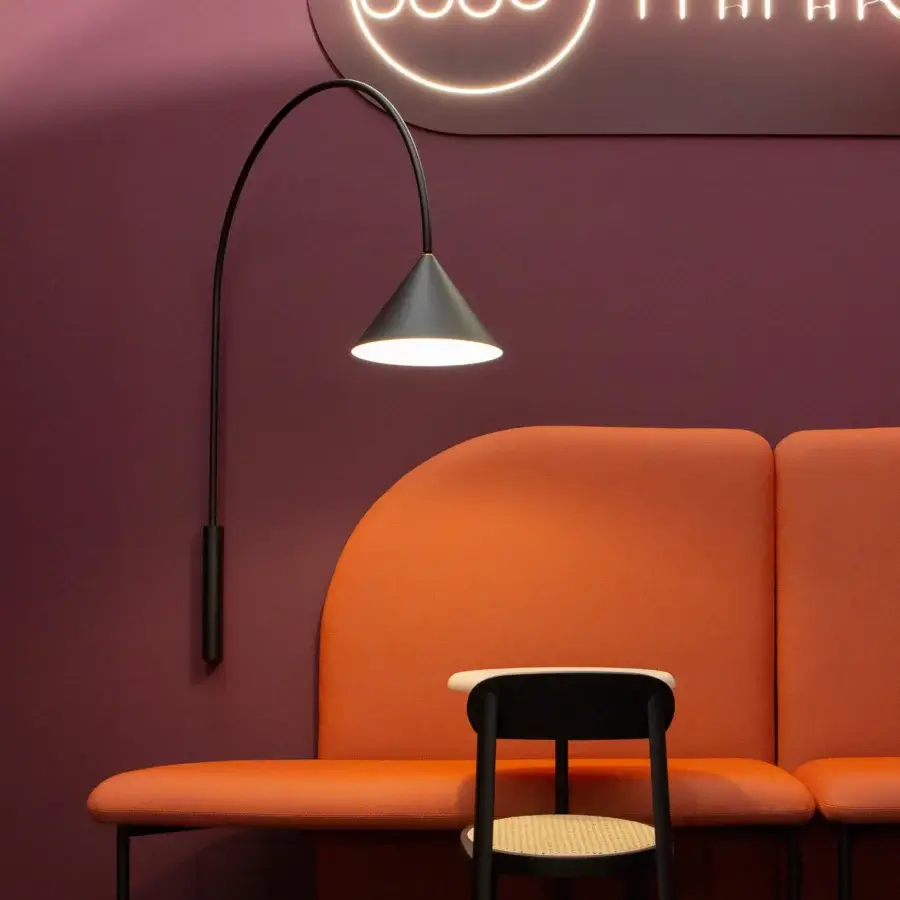 Exclusive Miniforms Ozz wall lamp with a slender curved metal arm and matte black cone-shaped shade crafted in Italy