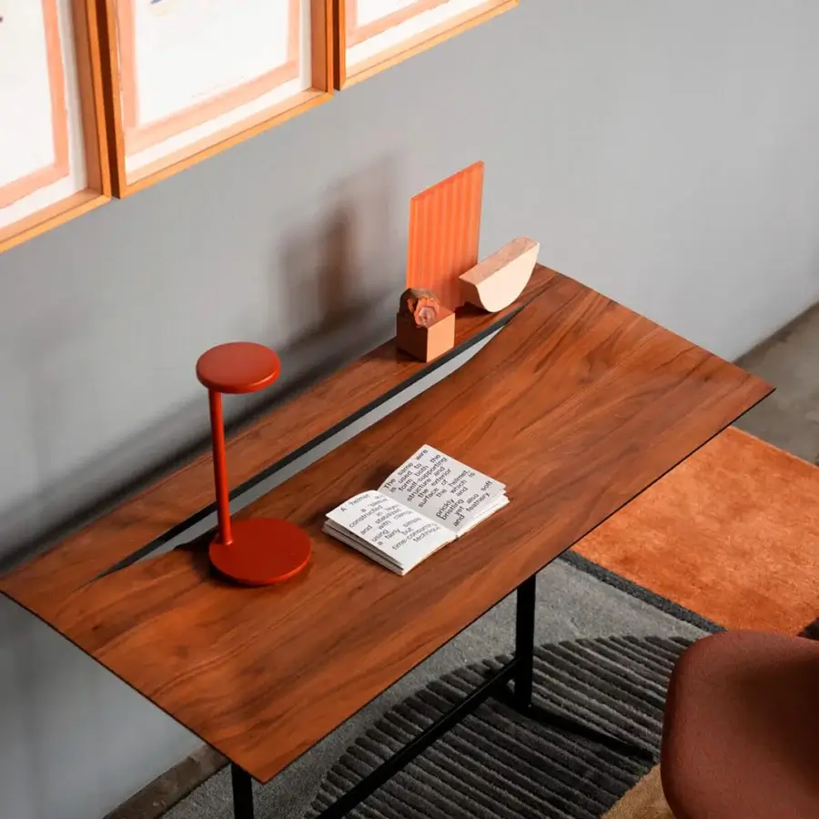 Elegant Bross Cut desk with a rich brown wood top bisected by a dark strip and black lacquered metal frame