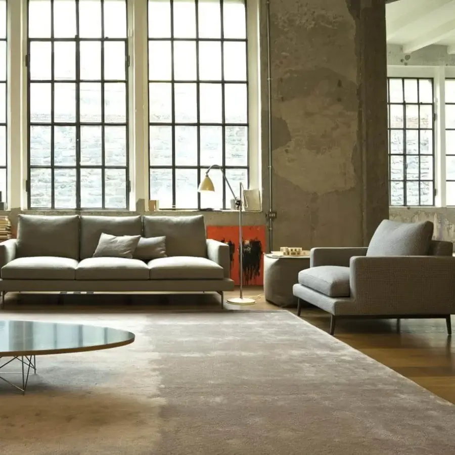 Elegant Verzelloni Larsen lounge chair with textured medium grey textile upholstery and dark base construction