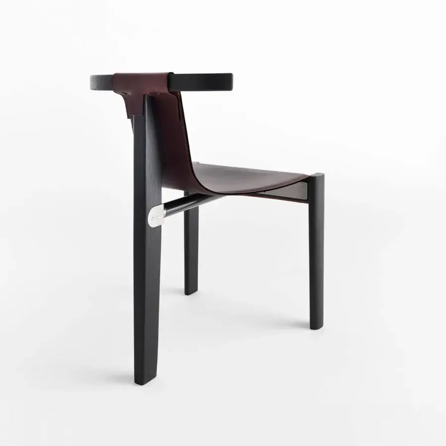 Distinguished Casamania Pablita chair with dark ashwood frame and suspended brown leather seat connected with stainless steel hardware