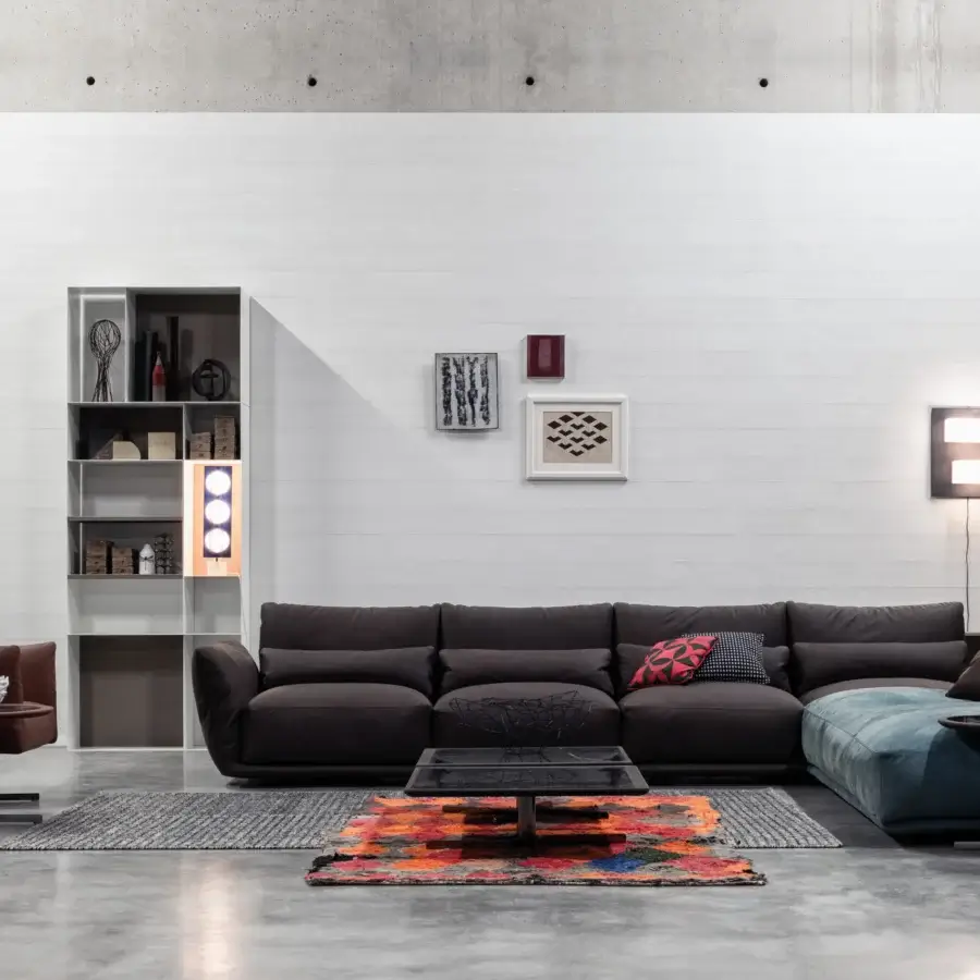 Distinguished Cierre1972 Clift sectional with dark brown textile upholstery, a blue chaise, and red-black patterned pillows