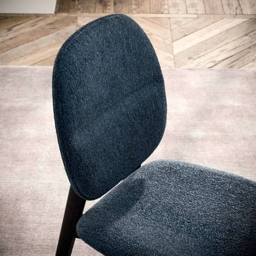 Harmonious Ozzio Italia Giotto chair with curved backrest and cushioned seat in textured blue textile with matte dark wood frame