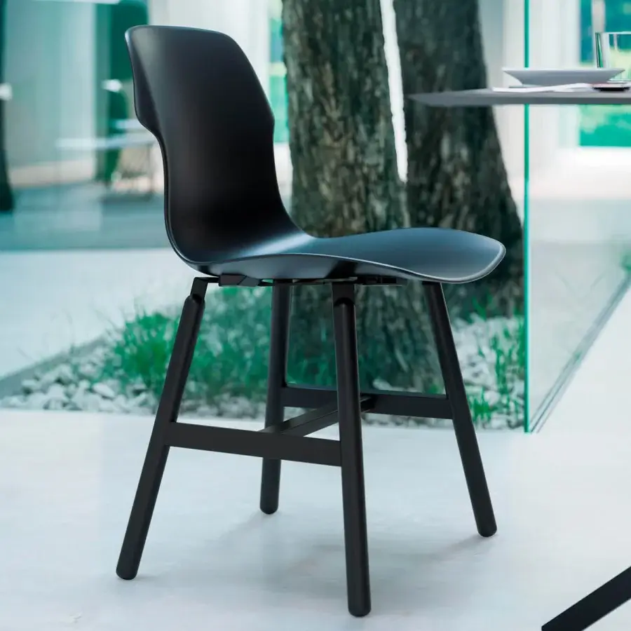 Elegant Casamania Stereo chair with curved backrest and contoured seat in matte black synthetic material with metal legs