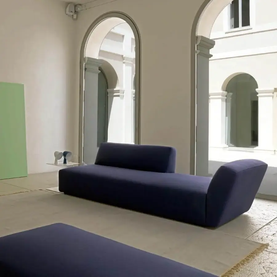 Superior Verzelloni Itaca sofa with a low silhouette upholstered in dark blue textile and black-stained beech feet