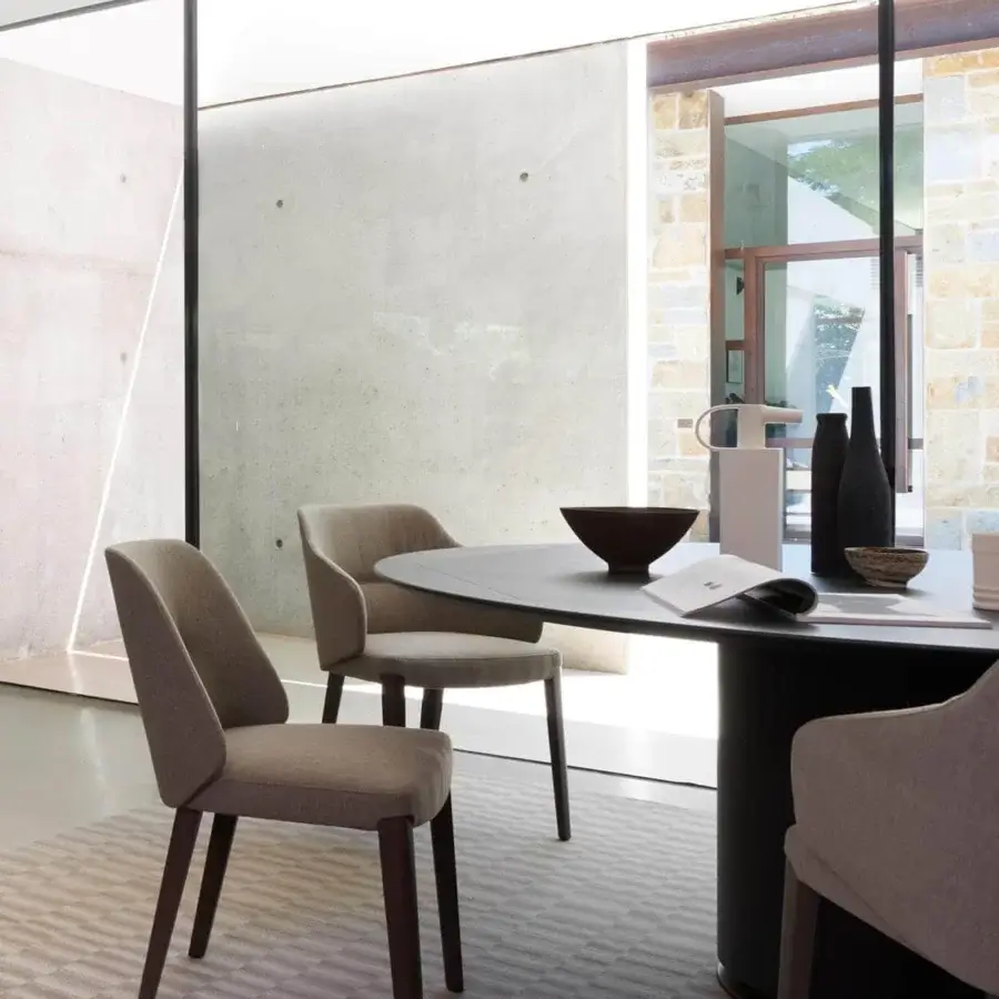 Sophisticated Potocco Concha armchair with enveloping form upholstered in light greyish-brown textile and dark-stained oak legs