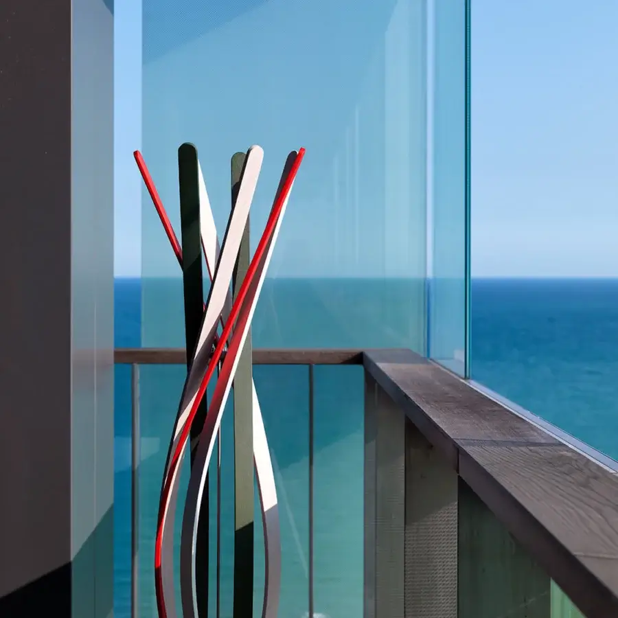 Superior Horm Twist coat stand crafted in twisting beech slats with contrasting black, white, and red finish