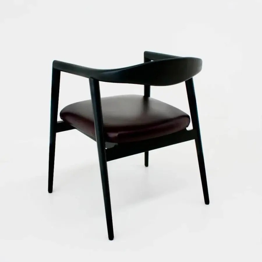 Sophisticated Casa Casati Romy armchair built with dark brownish-burgundy leather and sleek matt black natural ash wood frame