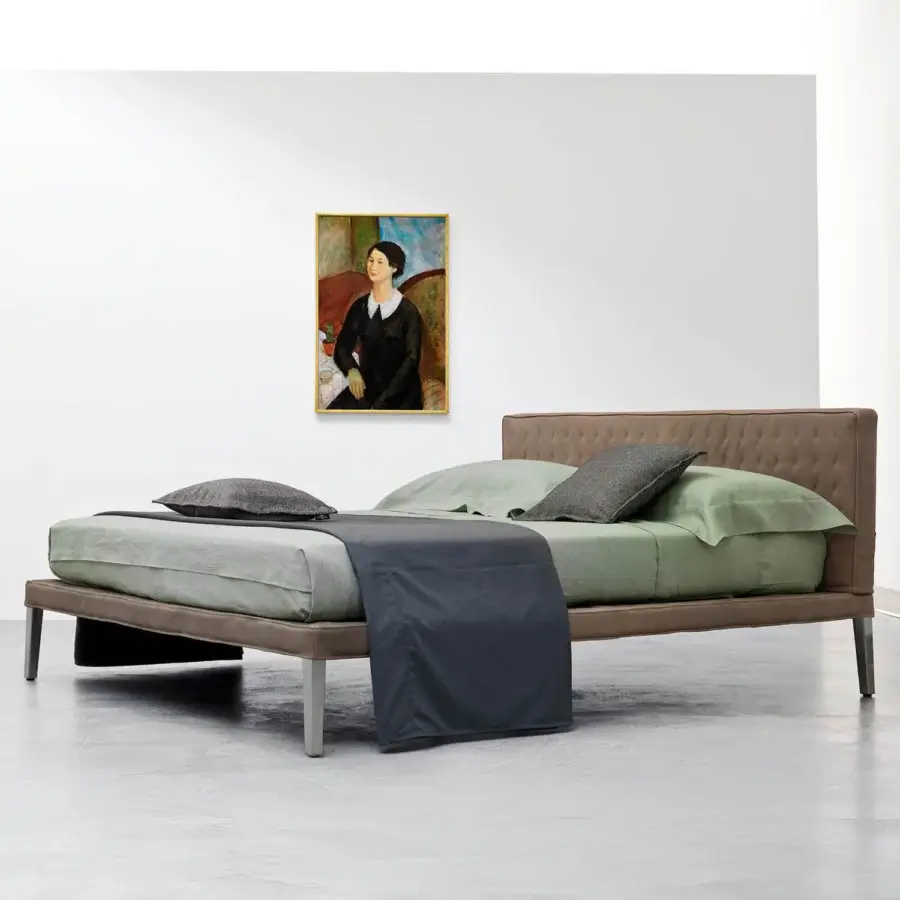Distinguished Horm Ebridi bed with smooth brown textile upholstery and quilted headboard built upon slim metallic legs with beechwood feet