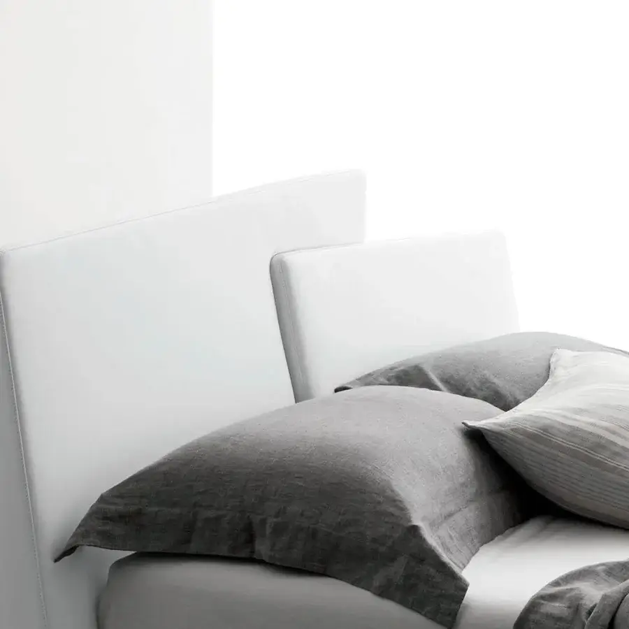 Harmonious Presotto Meeting bed with trapezoidal panels upholstered in smooth matte white synthetic material and grey textile pillows