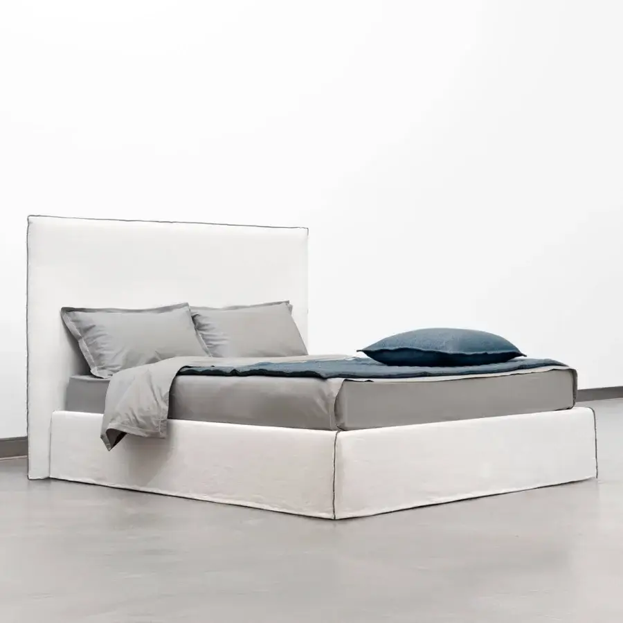Superior Horm Tahiti bed with white textile upholstery, dark trim and mocha lacquered beechwood feet