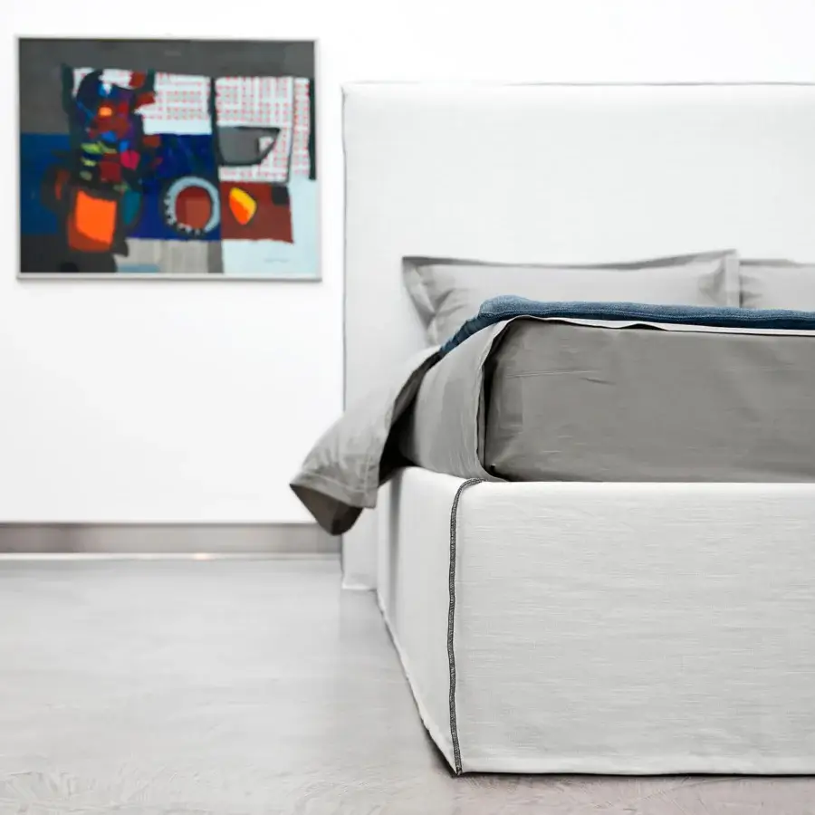Exceptional Horm Tahiti bed with white textile upholstery, dark gray stitched trim and lacquered beechwood feet