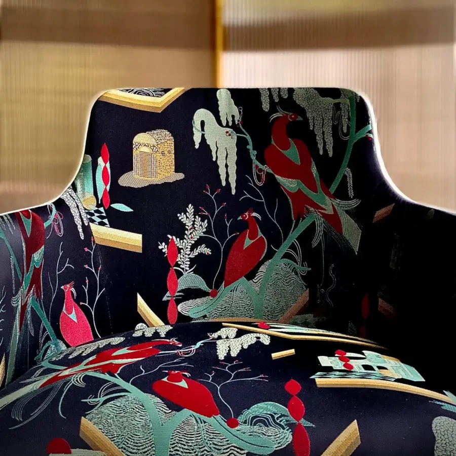 Distinguished Casa Casati Lola Royale chair upholstered with colorful fabric displaying birds, foliage, and geometric forms against a dark background