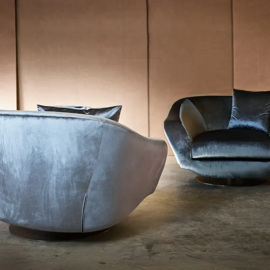 Distinguished Casa Casati Grande lounge chair with curved form upholstered in plush blue-gray textile and gold chrome revolving base
