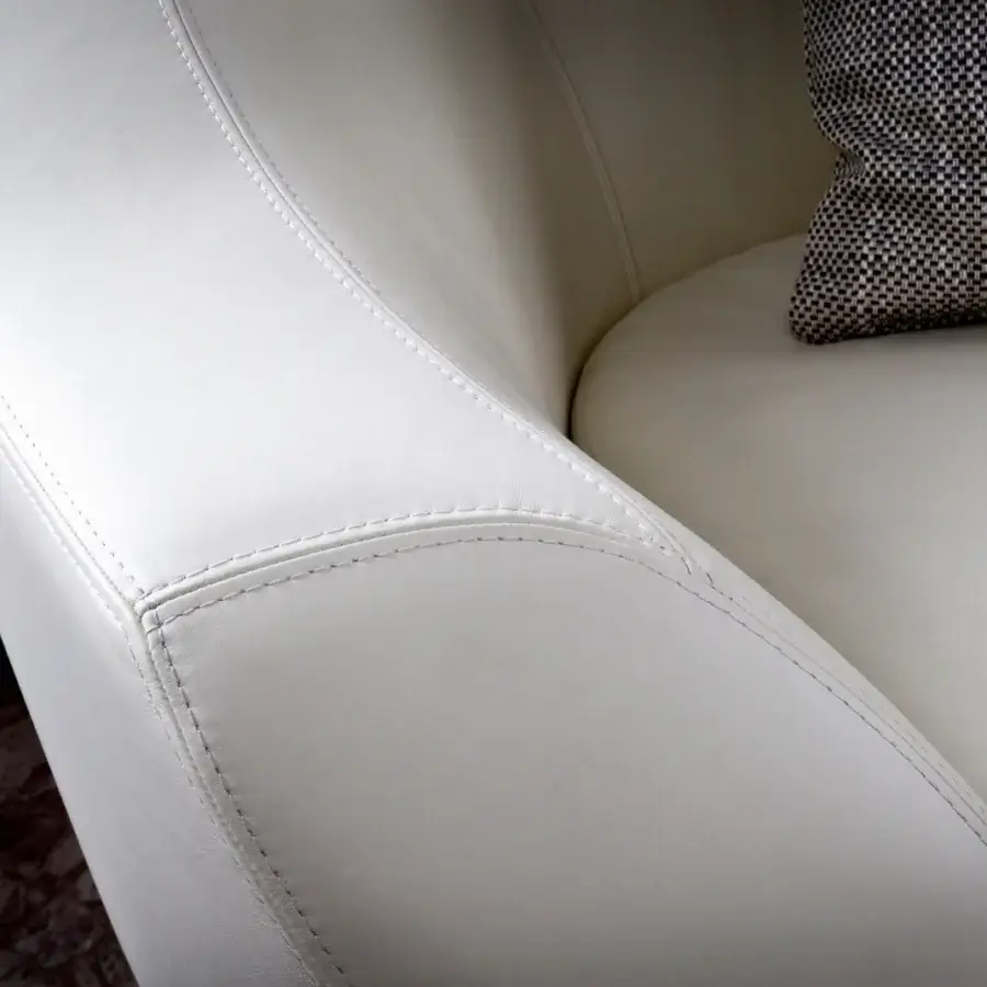 Lavish Casa Casati Grande lounge chair upholstered in smooth white material with detailed stitching and textured pillow