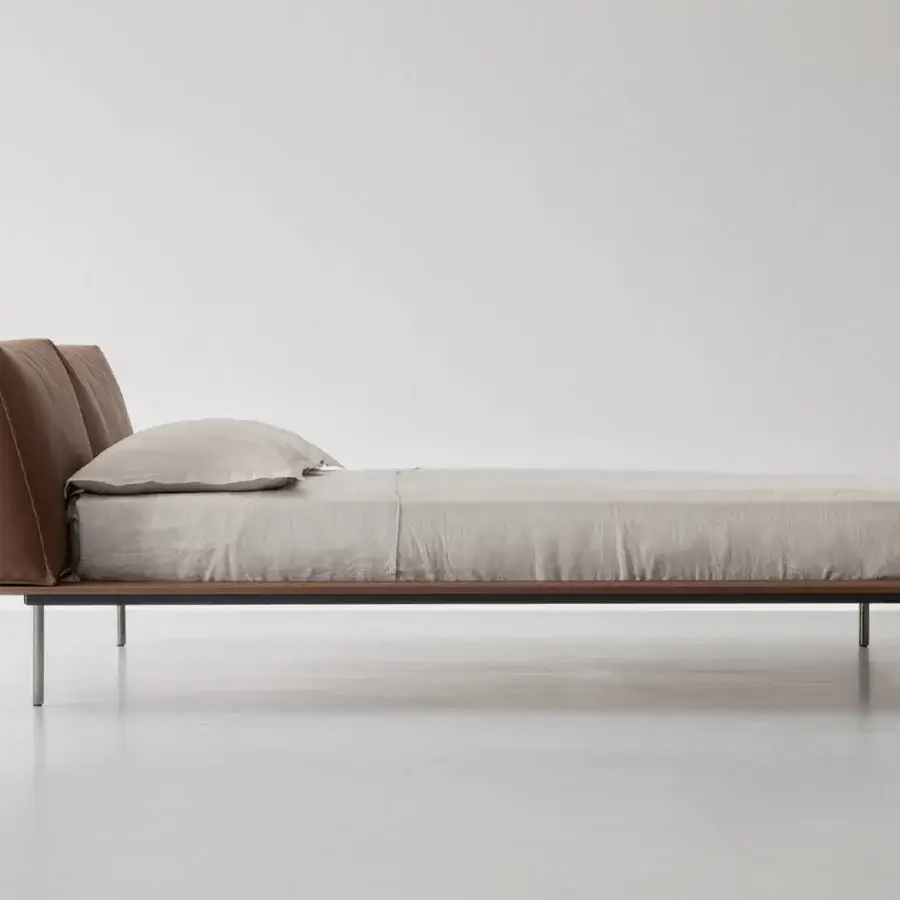 Elegant Cierre1972 Vogue Cuoio bed with rich brown leather upholstery and dark wood frame built atop brushed metal legs