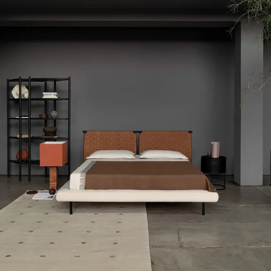 Exceptional Cierre1972 Jared bed with handwoven leather headboard and light textile base built on slender black metal legs