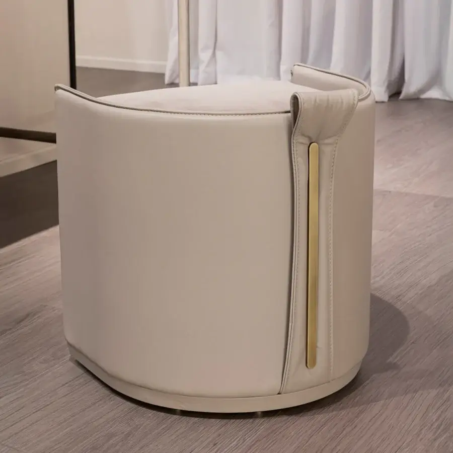 Superior Turri Vine ottoman showcasing cylindrical form with light beige leather and fabric, accented by brushed gold metal detail
