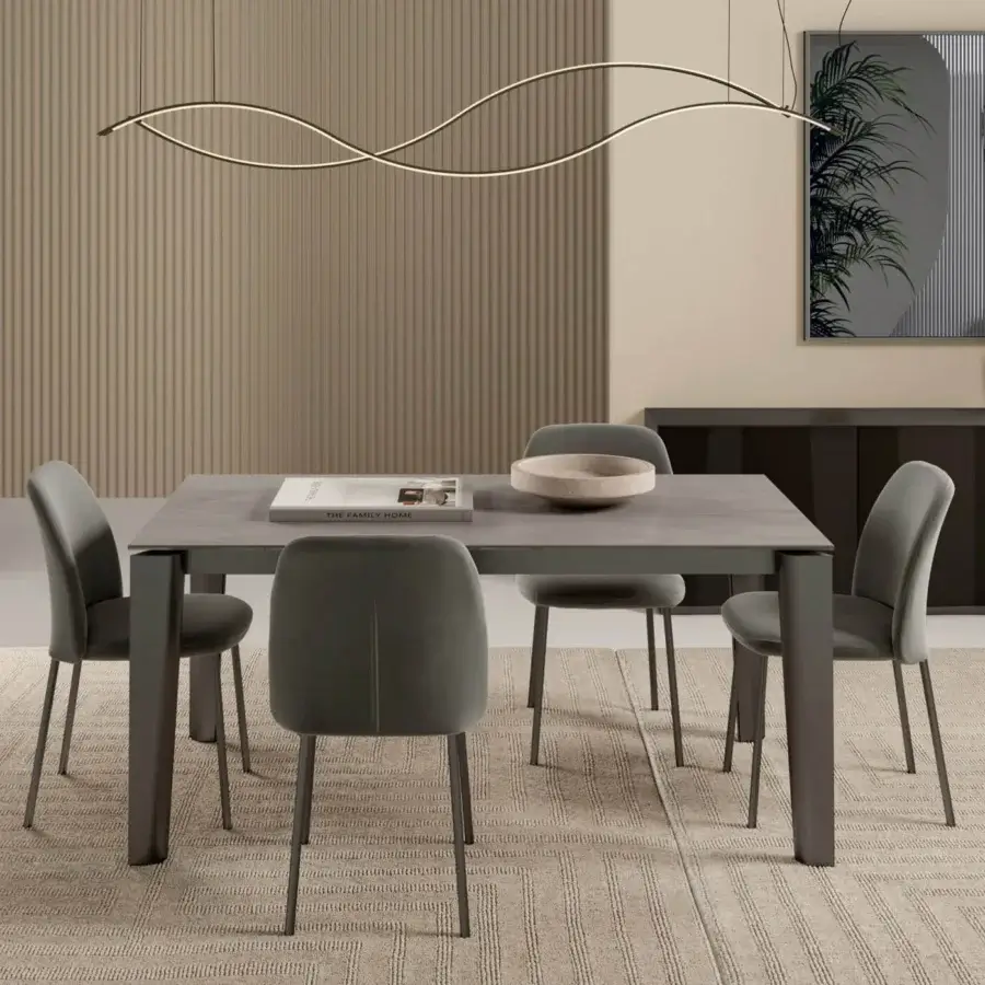 Bontempi dining table with matte gray rectangular top, dark gray base, six sage green upholstered chairs, gray rug, beige ribbed wall panels.
