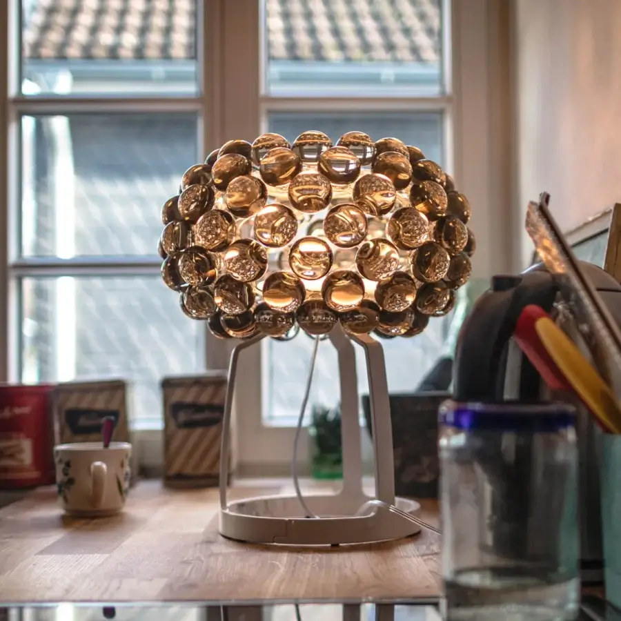 Captivating Foscarini Caboche Plus table lamp with numerous amber PMMA spheres and satin-finish blown glass internal diffuser in die-cast aluminum
