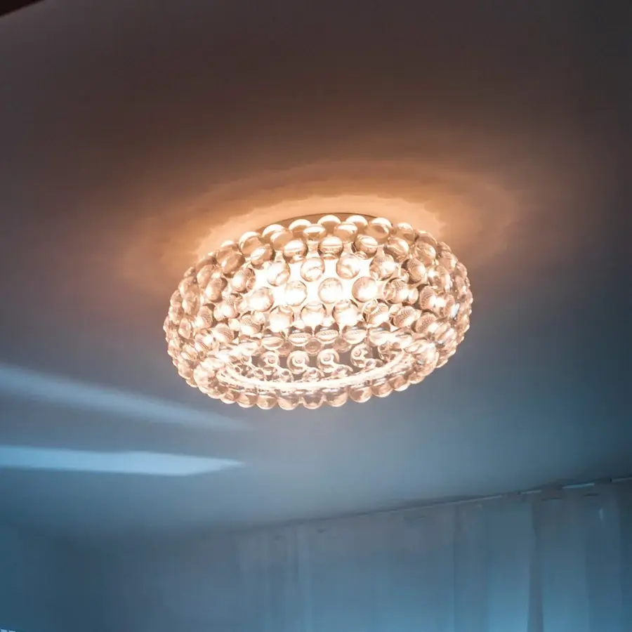 Captivating Foscarini Caboche Plus ceiling lamp with numerous light amber PMMA spheres affixed to a transparent PC structure and glossy finish