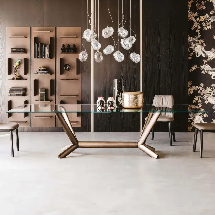 Distinguished Cattelan Italia Planer table with a transparent glass top and bronze painted steel legs exhibiting oblique volumes