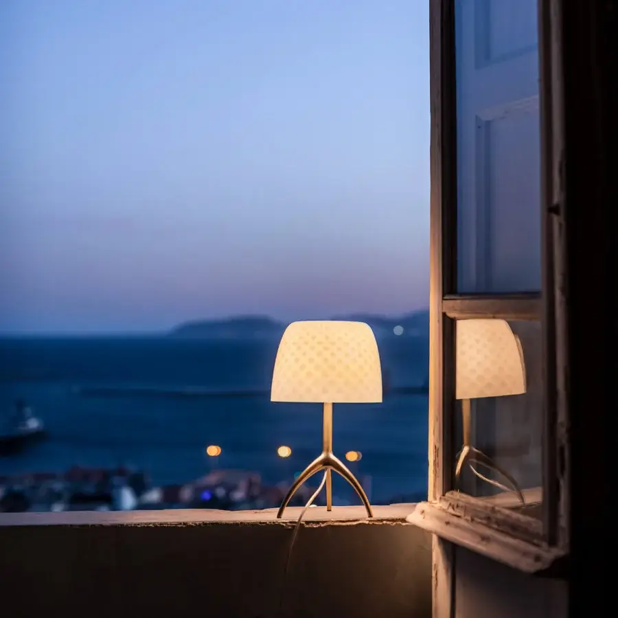 Elegant Foscarini Lumiere table lamp with a glossy cased glass diffuser and hand-finished die-cast aluminum tripod base