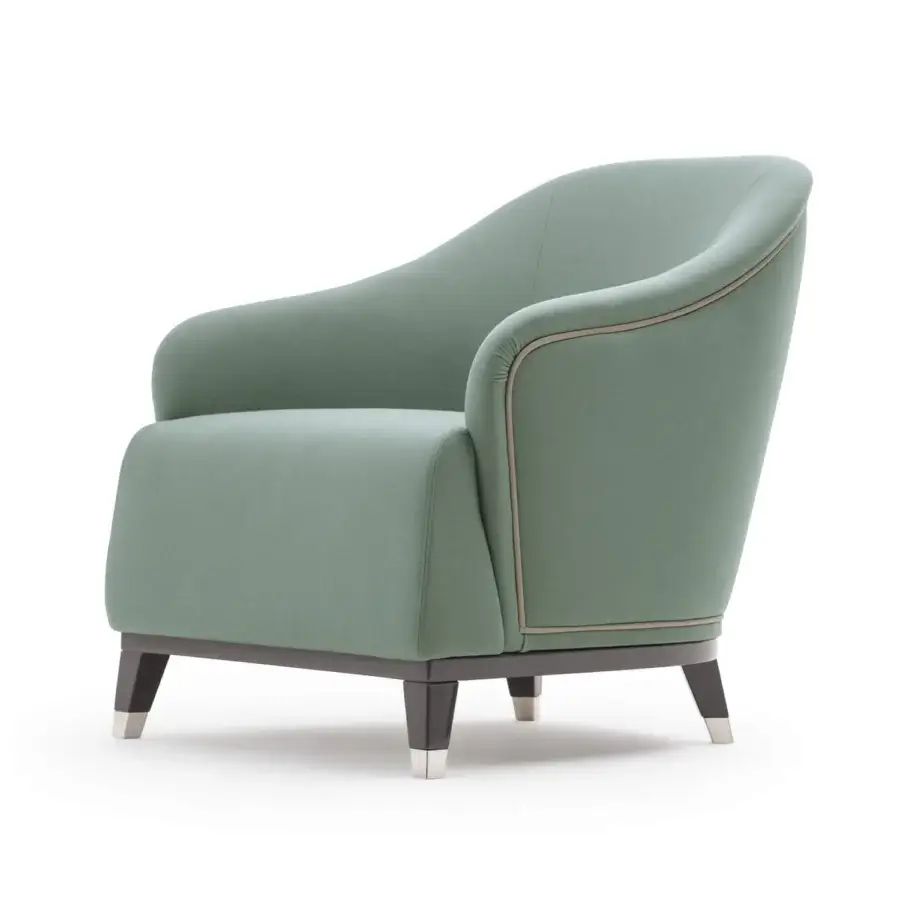 Elegant Turri Jolly lounge chair with enveloping lines upholstered in smooth matte green textile and dark wooden legs