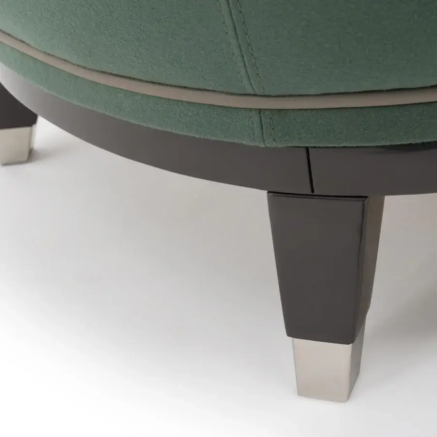 Elegant Turri Jolly lounge chair with enveloping lines in muted green textile and light tan trim with a dark wood-like base and metal accents