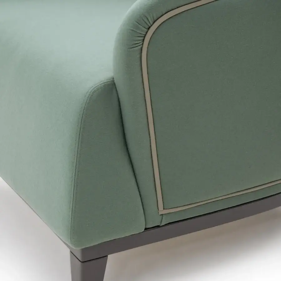 Distinguished Turri Jolly lounge chair with enveloping lines upholstered in muted green textile and matte finish with dark wooden legs