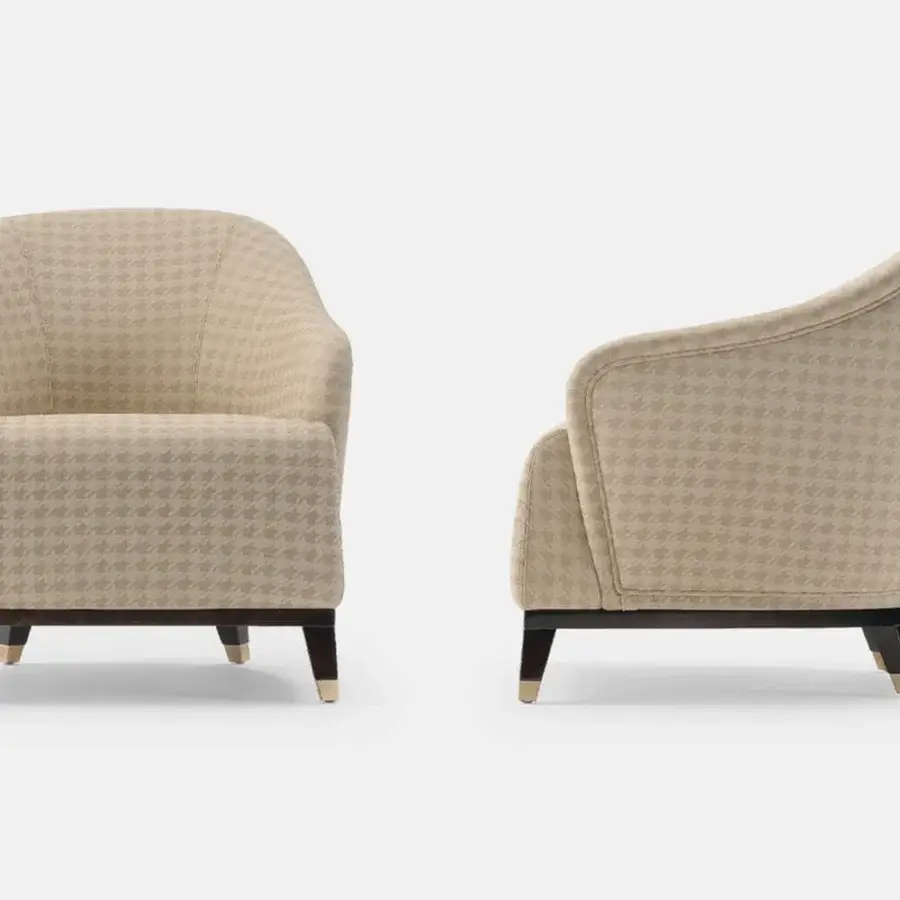 Superior Turri Jolly lounge chair with enveloping lines upholstered in light tan and beige houndstooth textile with dark wood and brass legs
