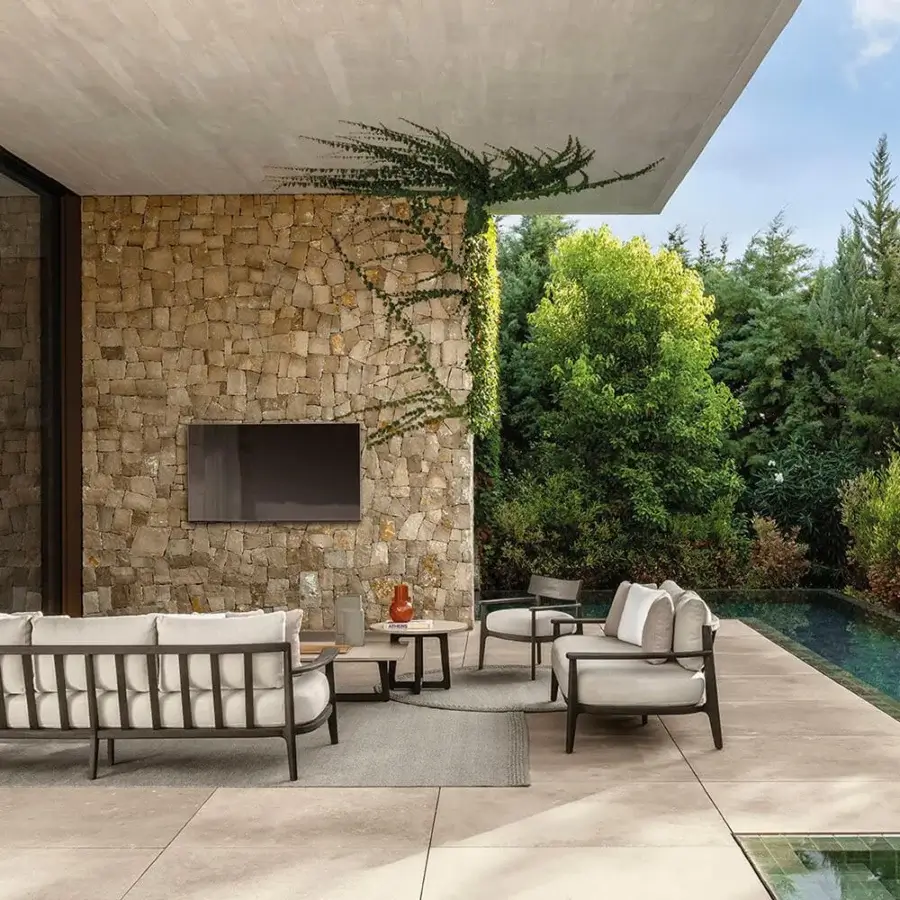 Distinguished Talenti Ever sofa with dark-toned wood frame and light textile cushions invites relaxation in contemporary outdoor spaces