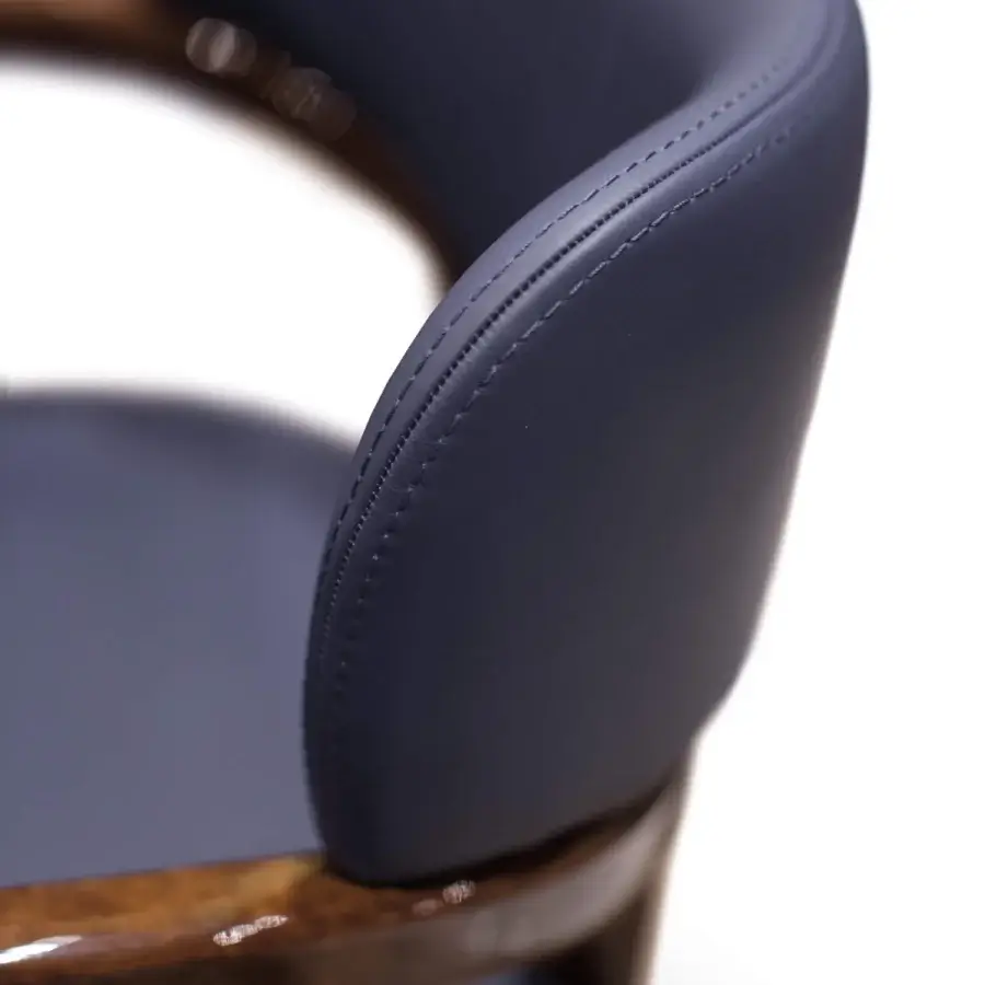 Distinguished Turri Madison armchair with curved form upholstered in dark blue synthetic material and light gold metal feet