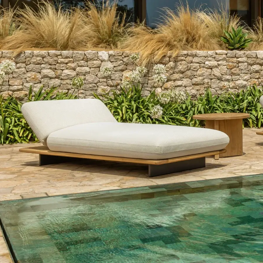 Distinguished Talenti Venice lounger with light beige cushions and warm-toned teak wood, evoking artisan finishes and a floating design