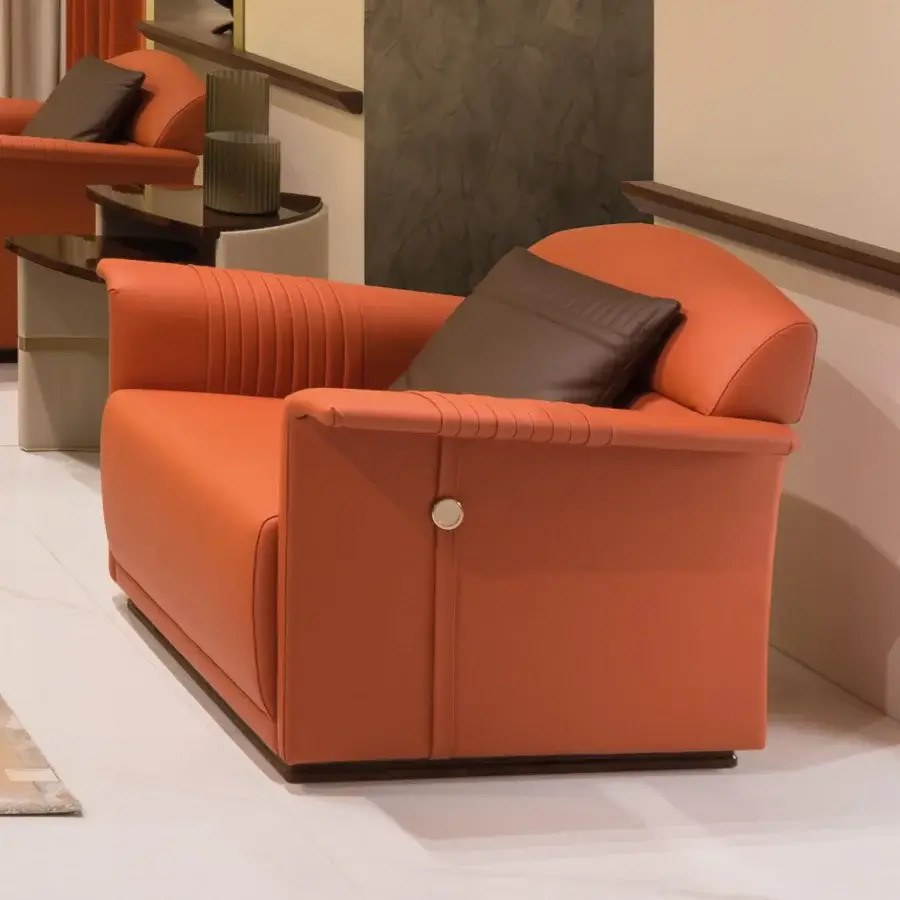 Distinguished Turri Madison lounge chair upholstered in vibrant orange material with vertical embroidery and metal button accents