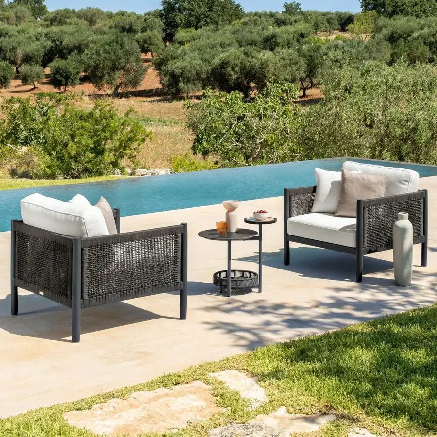 Distinguished Talenti Dolcevita Alu lounge chair with dark metal frame and woven synthetic sides offering comfortable off-white cushions