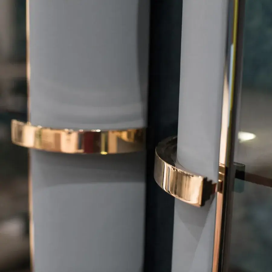 Elegant Turri Madison bar cabinet in muted gray with light gold metal accents and illuminated mirrored compartment